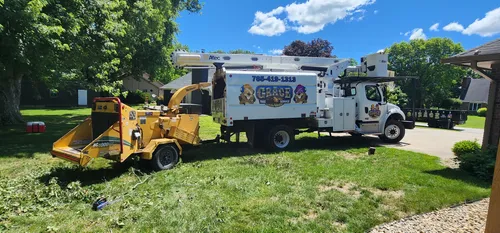 Bucket truck and wood chipper clearing branches