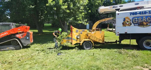 Crew feeding branches into the wood chipper